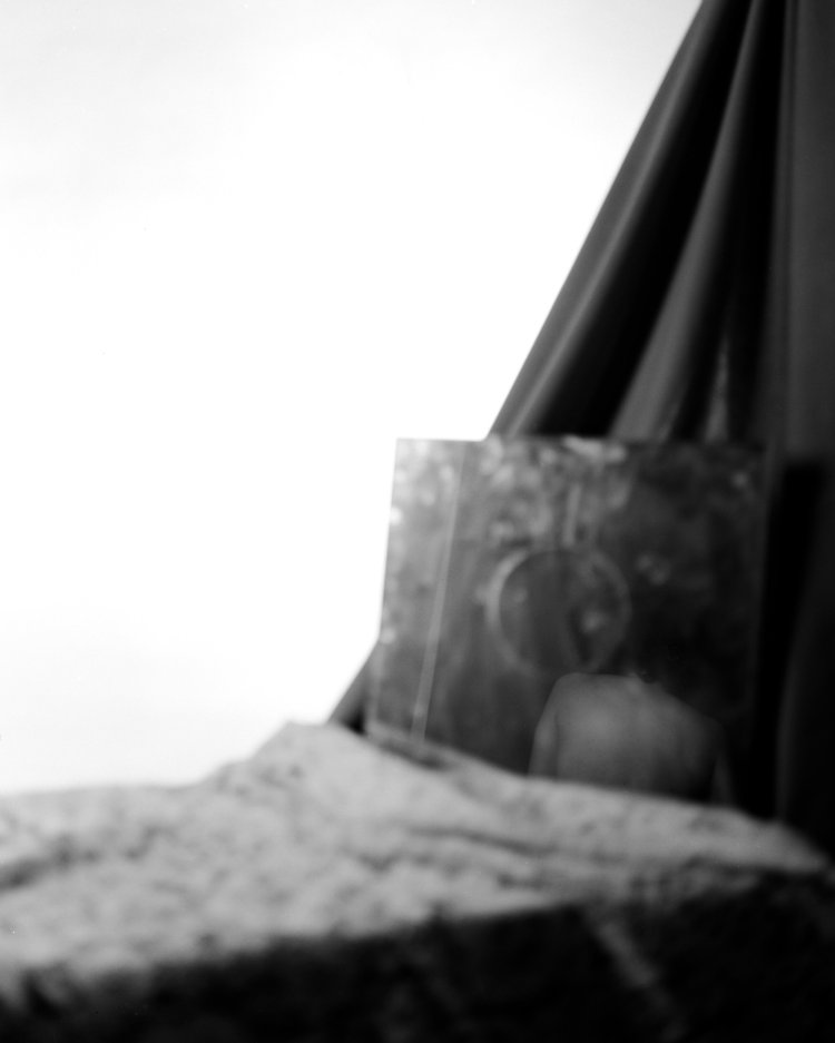 Photograph of an obscured figure in a mirror